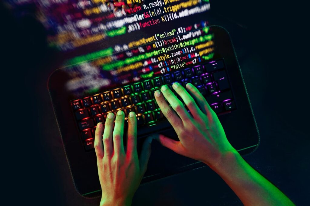 Man's hands on keyboard with programming background