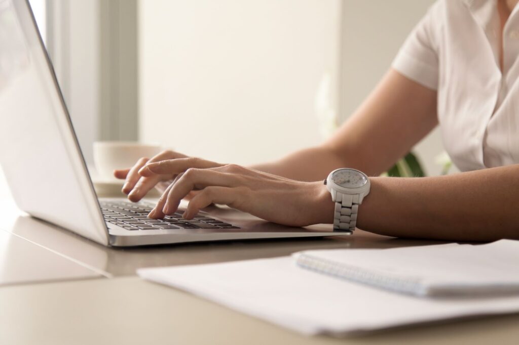 Close up of woman typing on her laptop